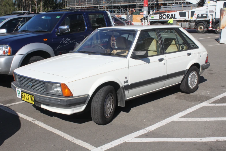 a white and black car sits in a parking space