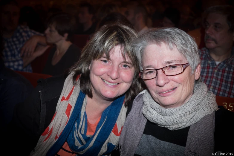 two women wearing scarves posing for the camera