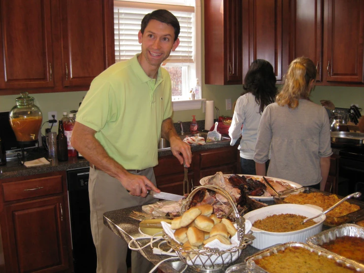 a man  some meat on a table in the kitchen