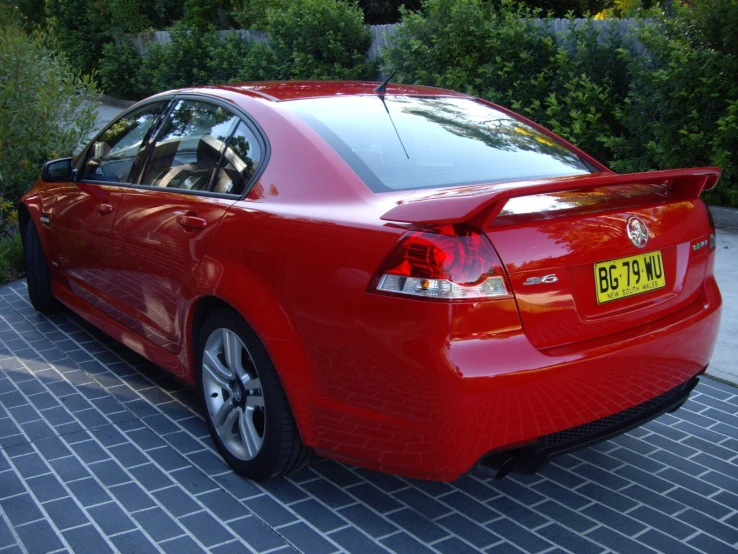 a red car that is parked on some bricks