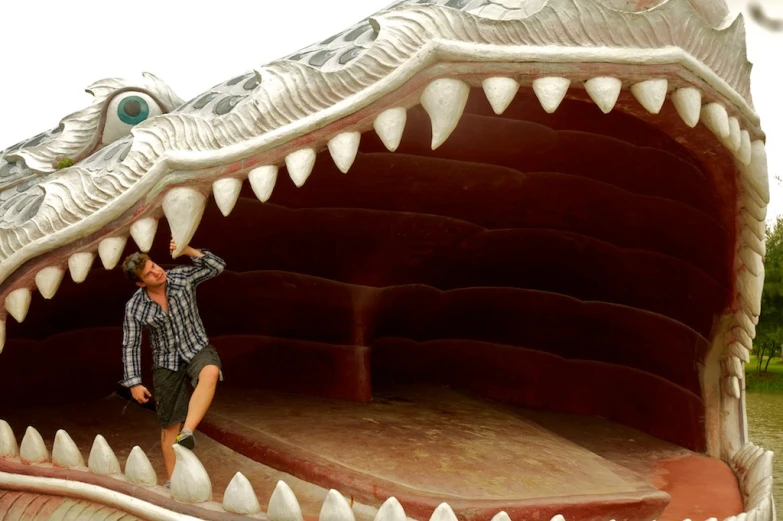 a man stands in the middle of an enormous alligator - like structure