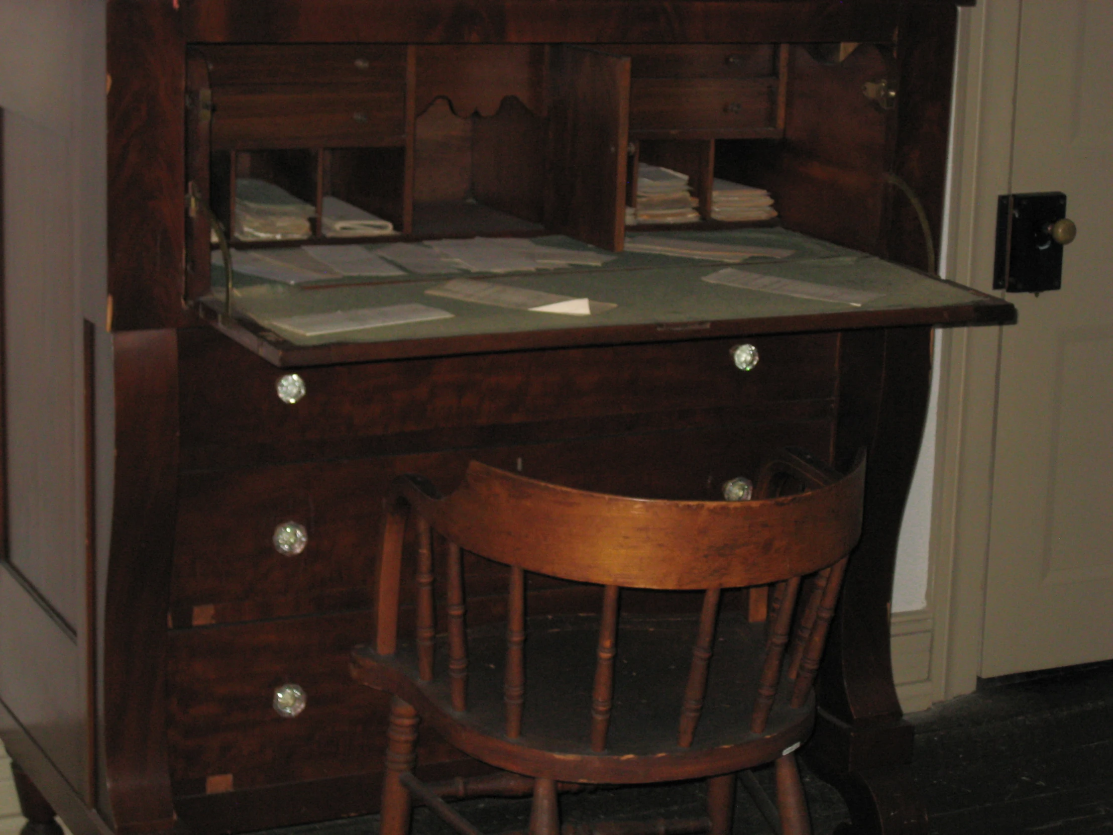 a desk with some drawers on it and two chairs