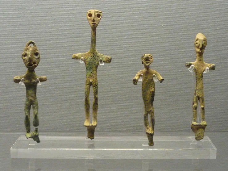 three figurines on a glass stand