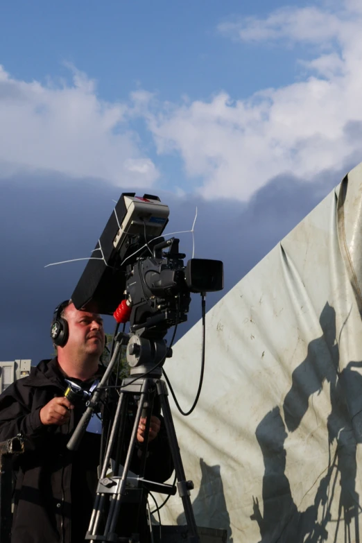 a man who is sitting with a camera and headphones