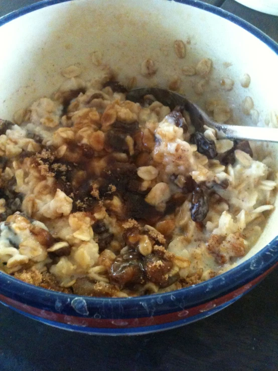 a bowl of cereal, topped with nuts, with spoon