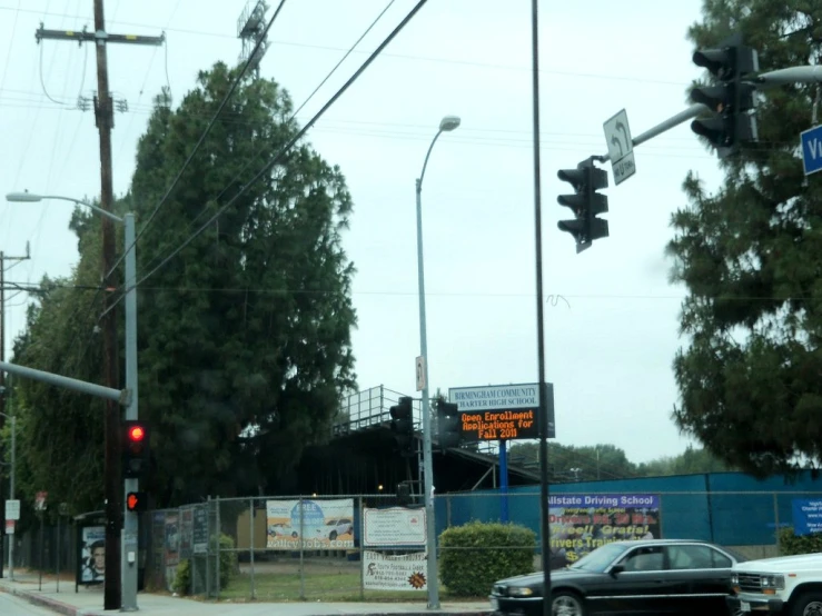 traffic signals and a black car are on the road