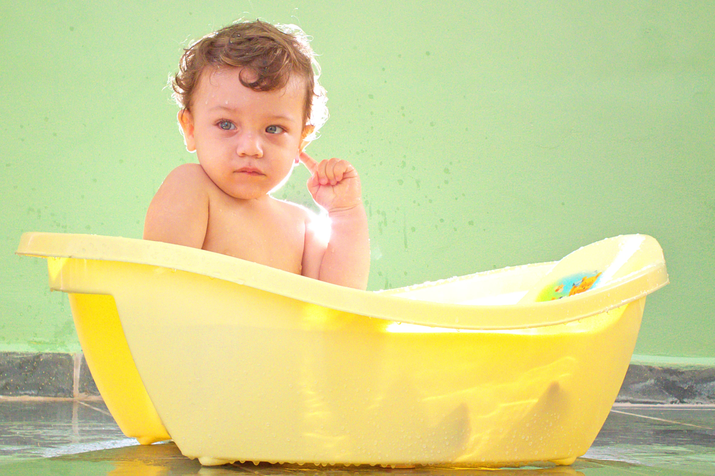 the small child is playing in the bathtub