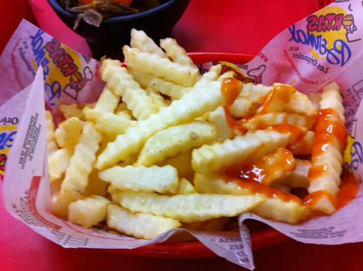 french fries on the side of a red plastic container