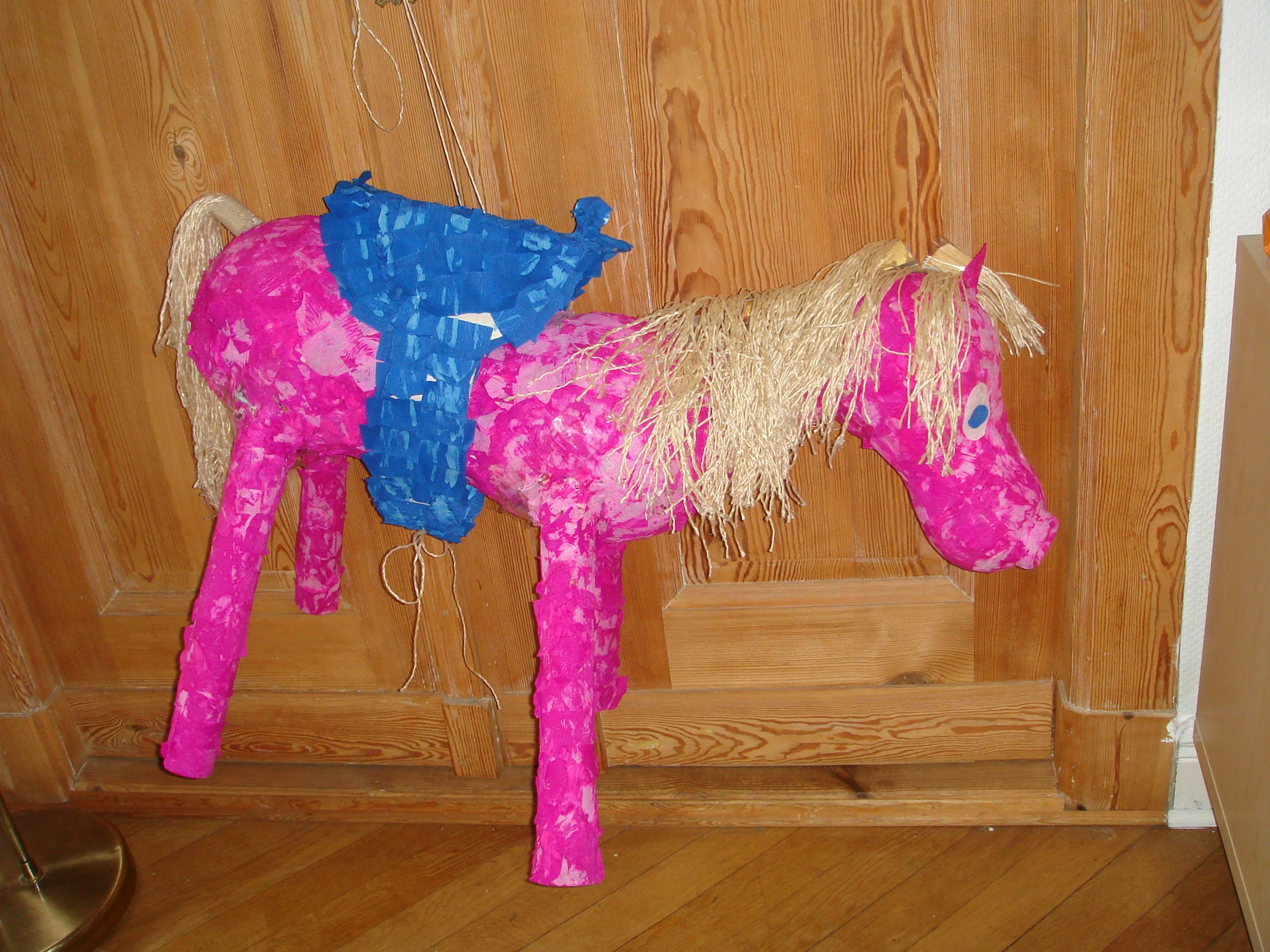 the pink and blue pony has a small blue bucket on its back