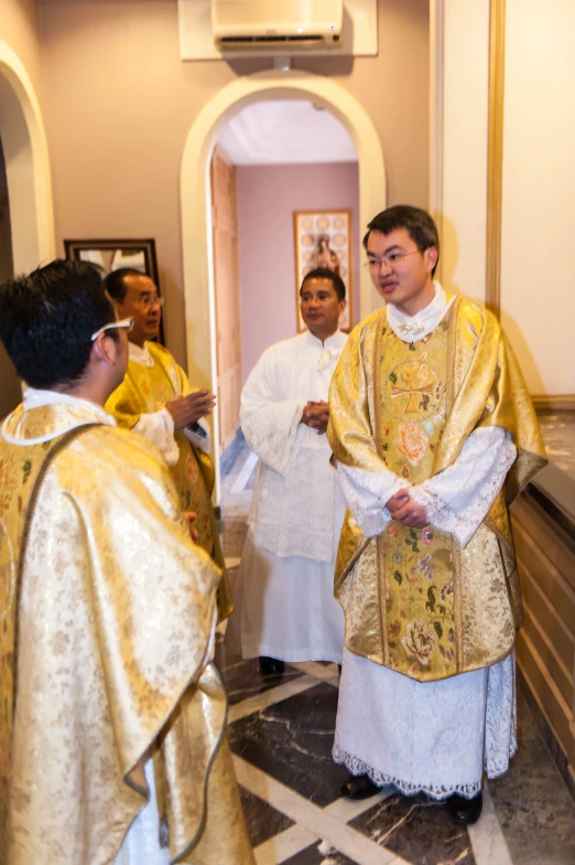 a group of people in white and yellow robes and the man in the church wears an ornately decorated stole