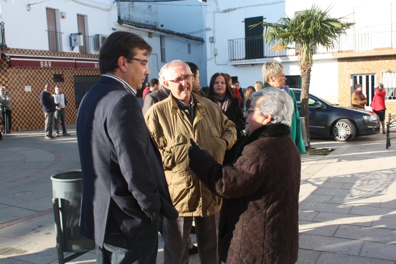 a woman holds onto a hand gesture with several people around