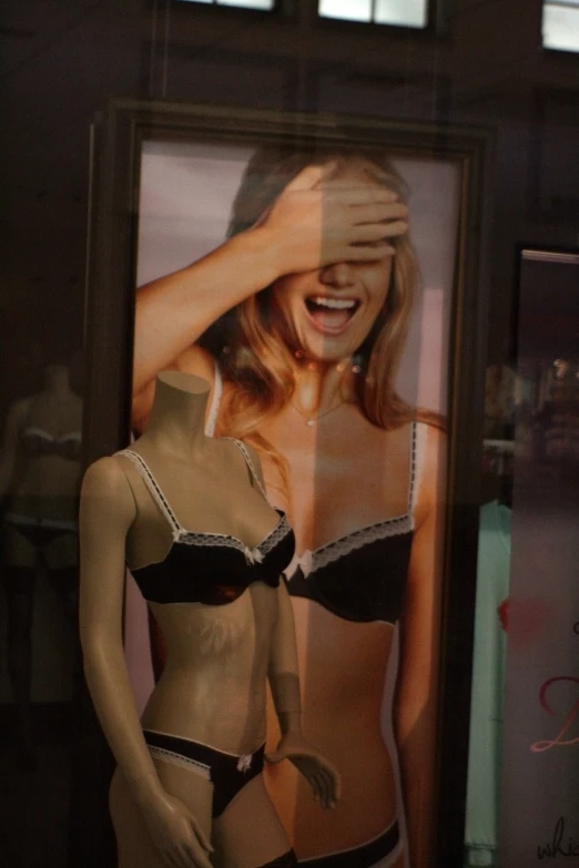 a mannequins display in a window featuring a girl's underwear and a po of a woman wearing lingerie