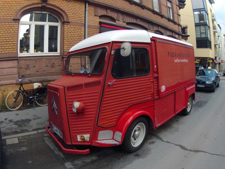 a red and white car parked in front of a building