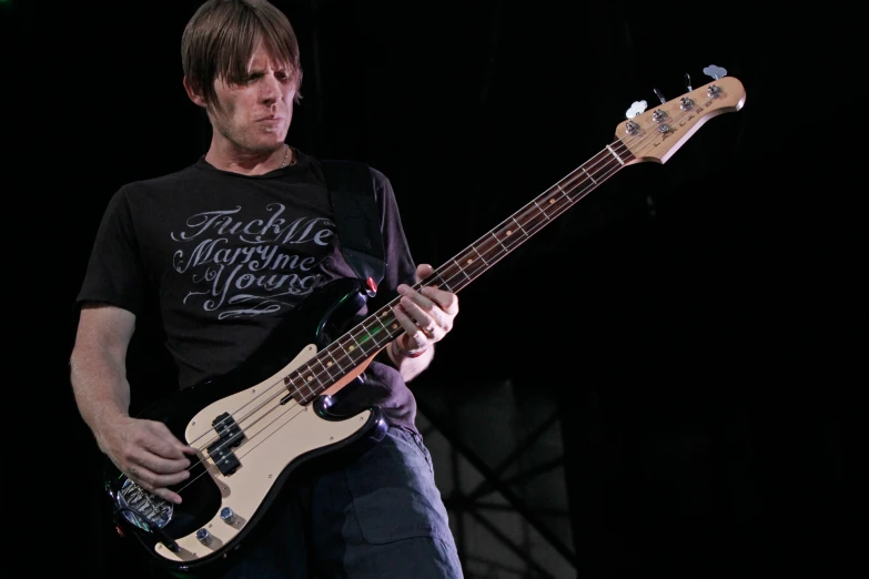 a young man with a large guitar on stage