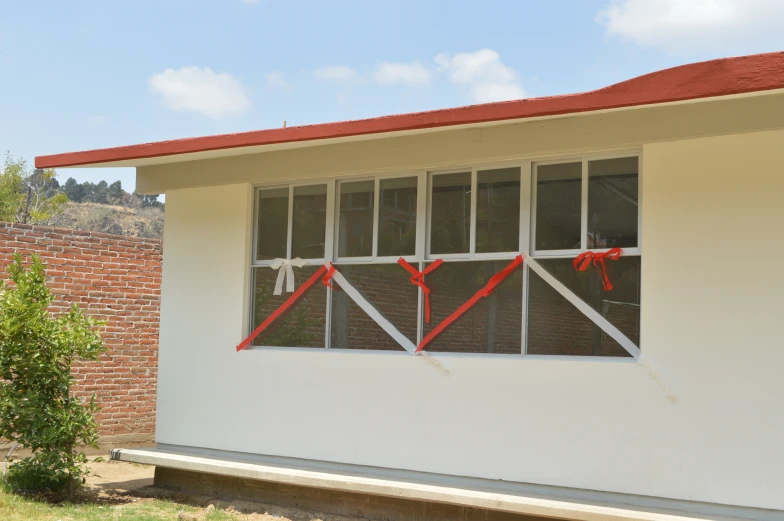 a white building with red ribbon attached to it