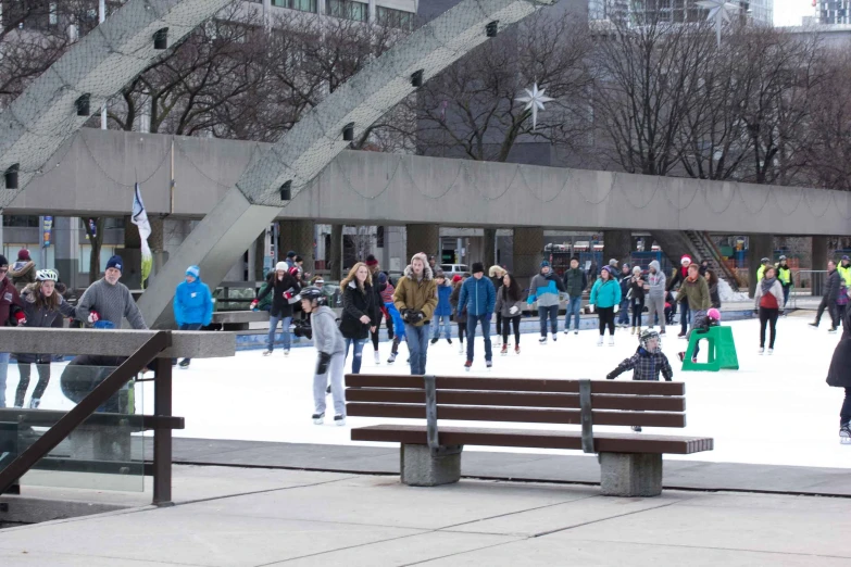 people on an ice rink skating on a sunny day