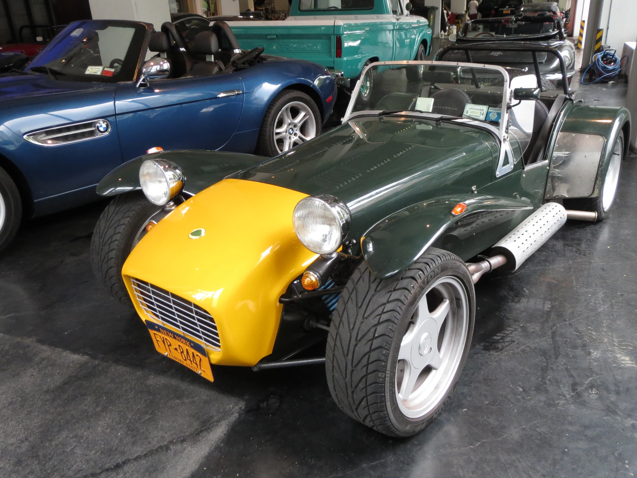 a green car with yellow top in an showroom