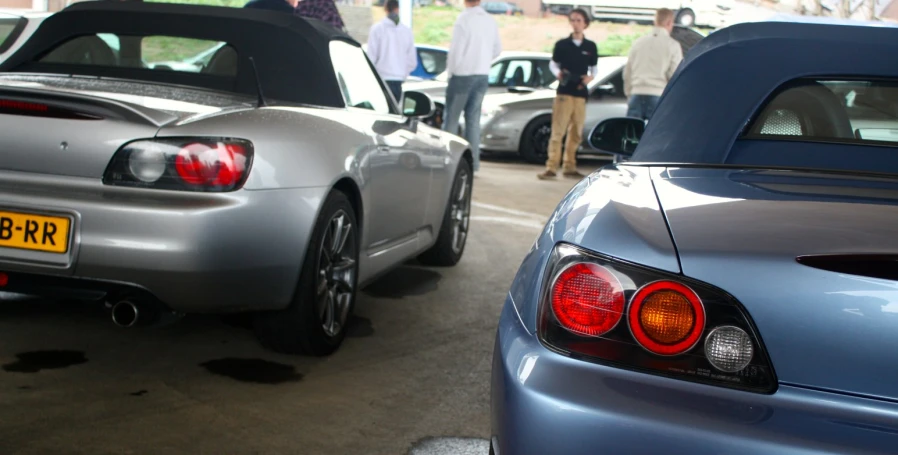 two blue sport cars parked on the side of a street