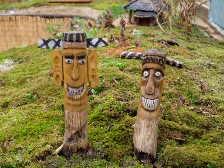 there are two wooden statues that look like heads and hands