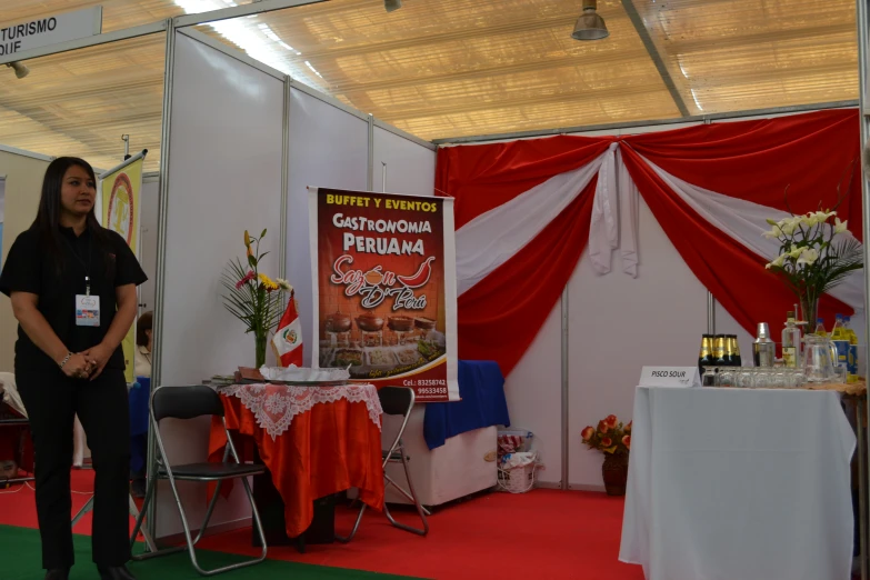 the woman stands in front of a booth for food products