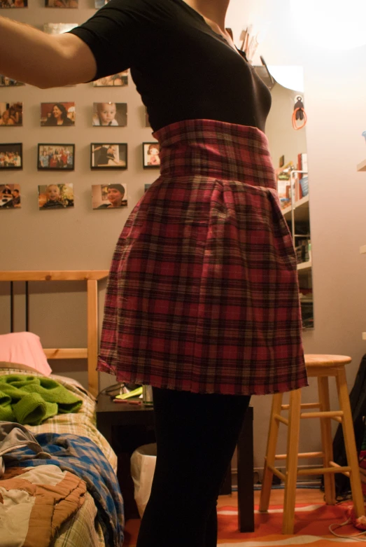 a woman in plaid skirt holding up a knife