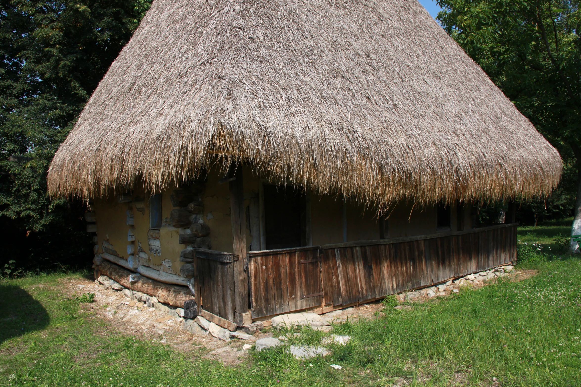 an old building has grass thatch on it