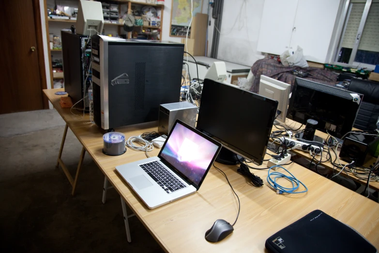 three computers sit on the table in front of a laptop