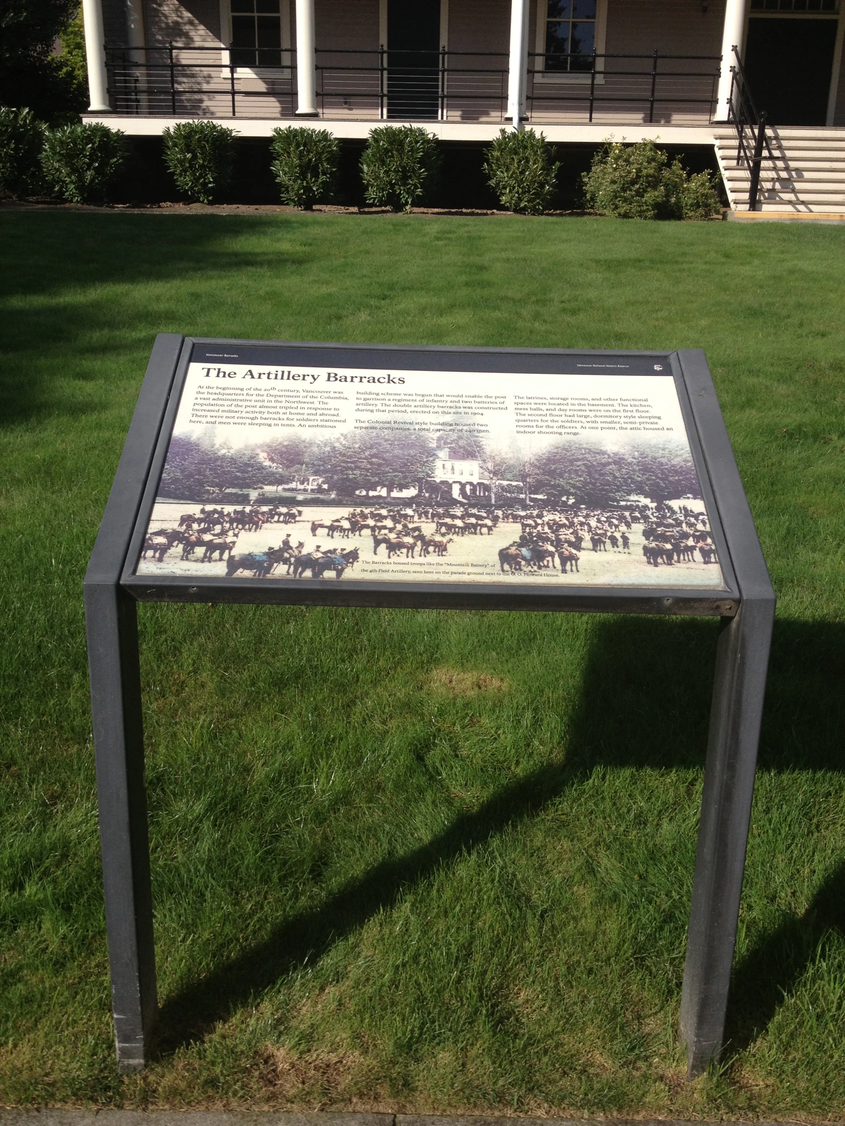 the historical marker of a town with horses on a sunny day