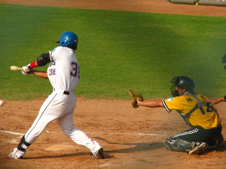 a baseball player holding a bat next to home plate