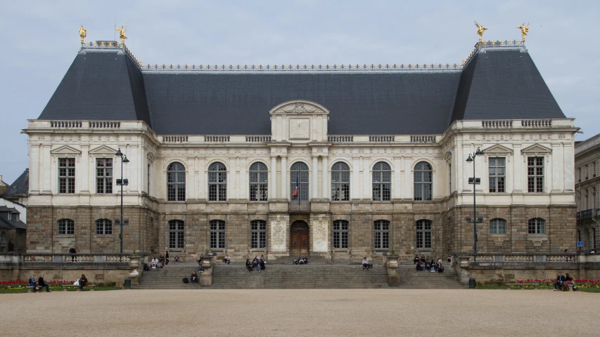 people are standing outside of a building with three levels