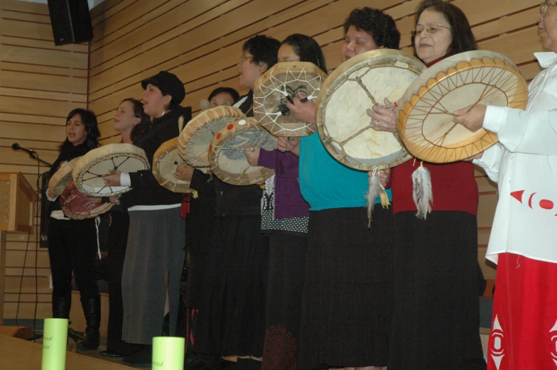 there are some people standing with a lot of different drums