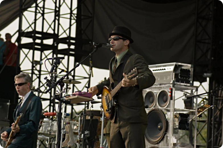 a man wearing glasses is playing guitar