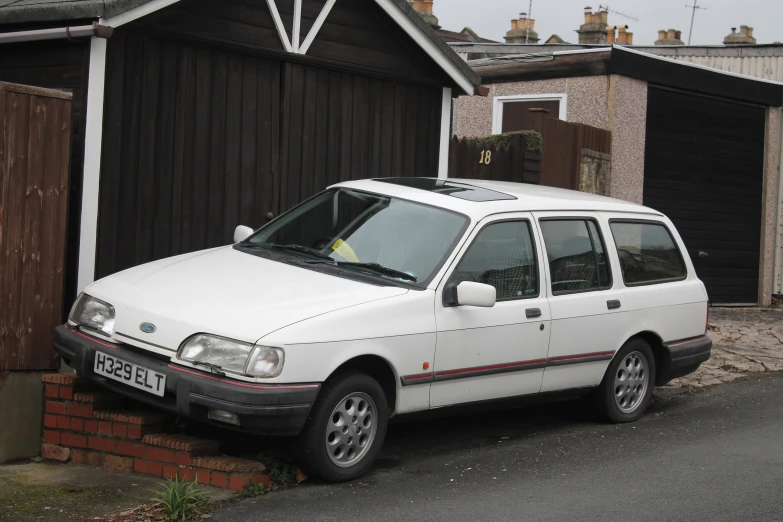 a white car parked in front of two houses