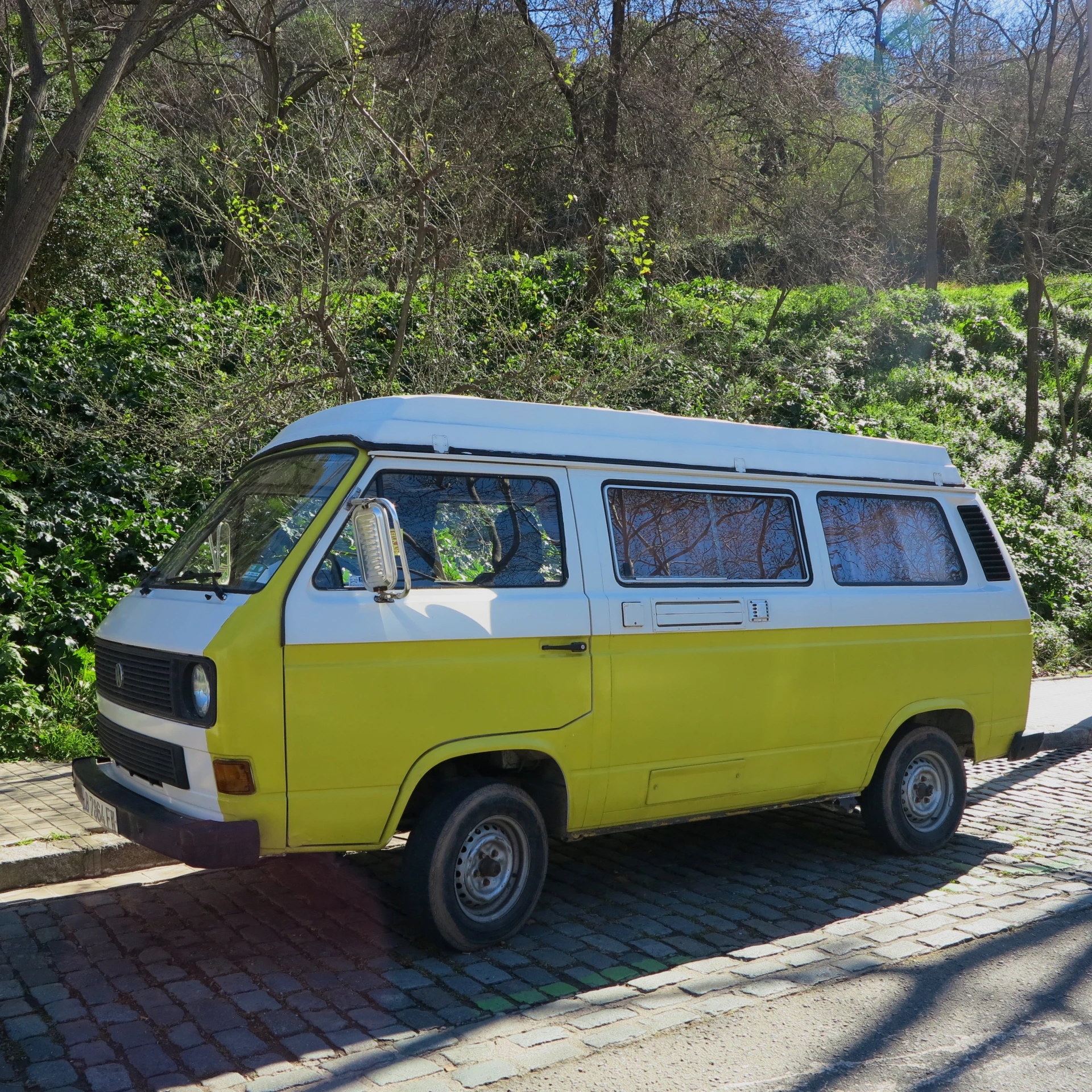 an old yellow van with a white top