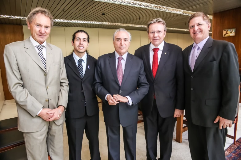 five business men are standing together and smiling