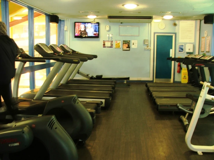 there is only one person standing by the treadmills