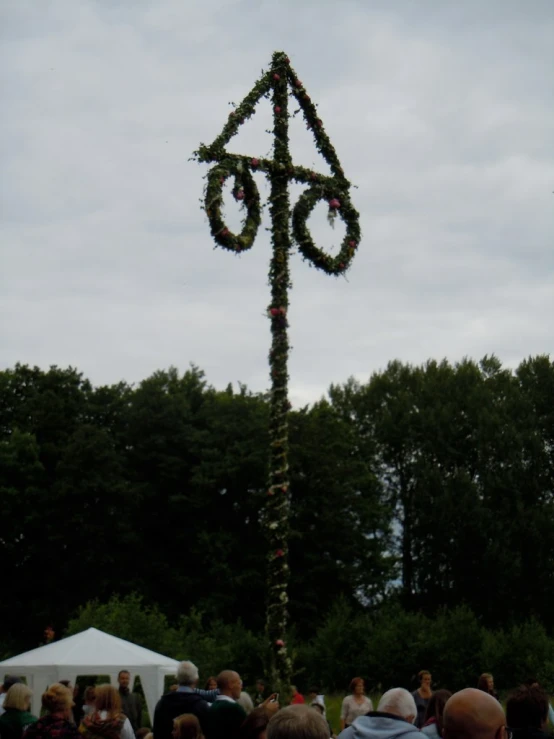 a number 66 made out of a tree with people standing around it