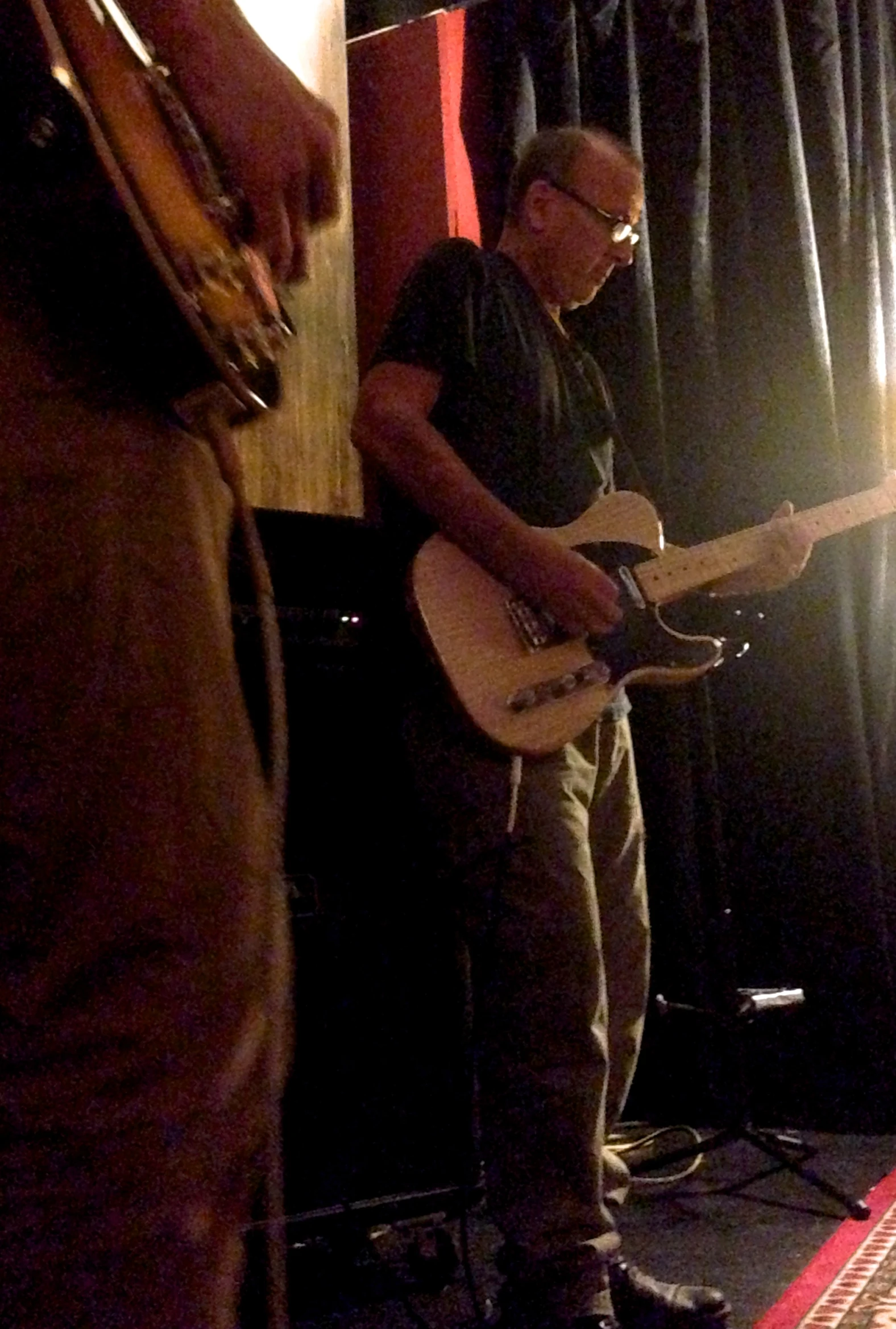 two men with guitars standing and talking