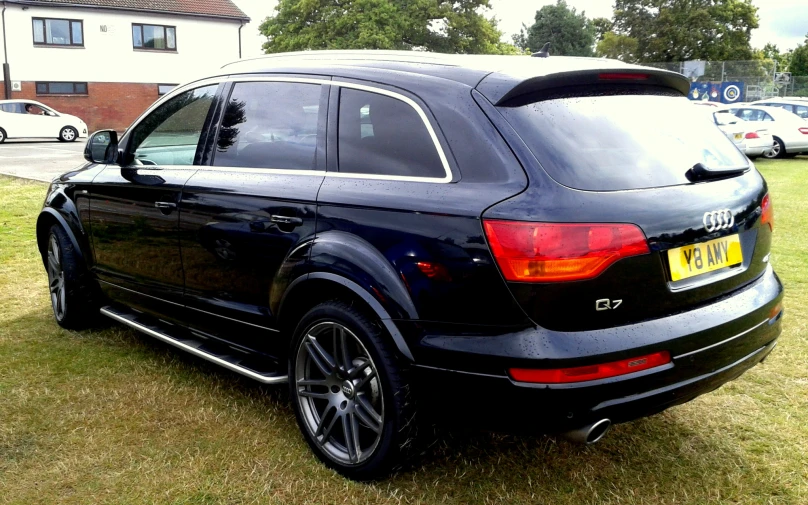 the car parked in a grassy field with other cars