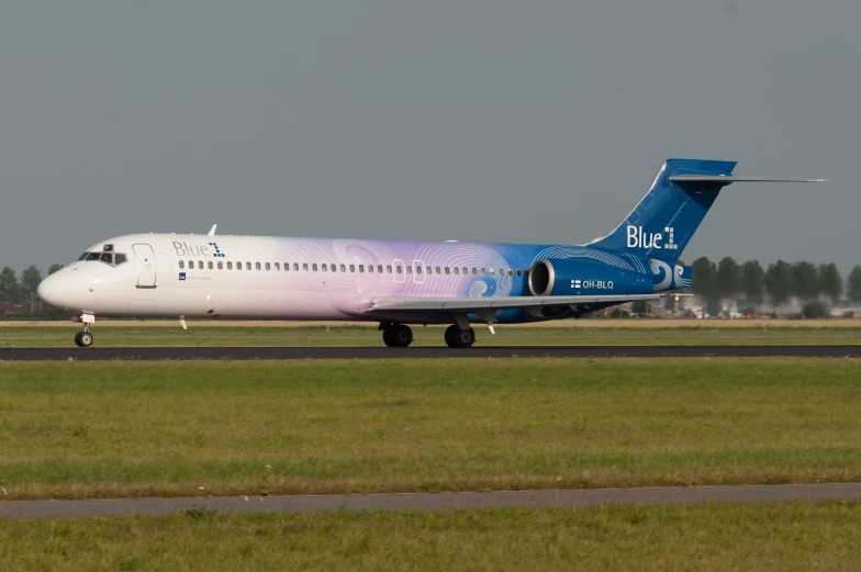 large airplane with blue on it sits on the runway