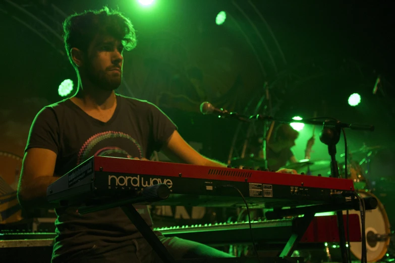 a man playing piano on stage during the night