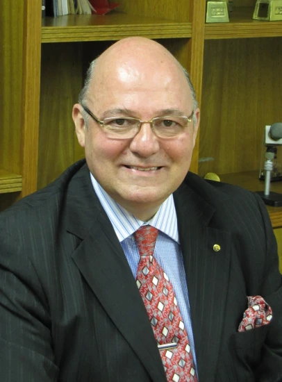an older man wearing glasses and wearing a suit
