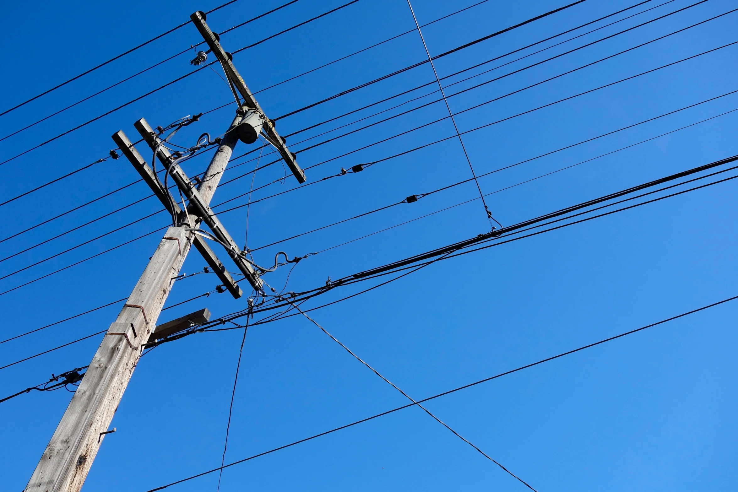 telephone pole with several wires and a blue sky