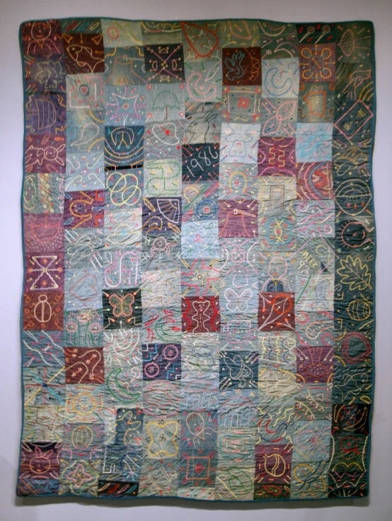a patchwork piece with many squares and swirls of colorful yarn