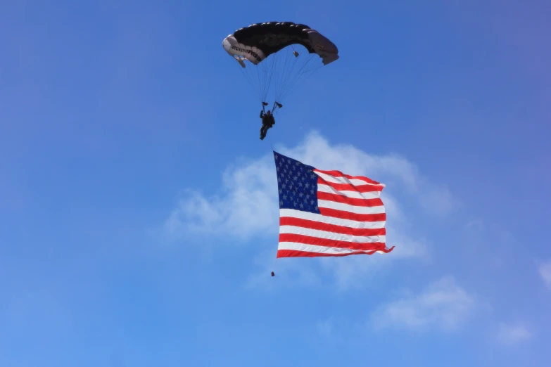 the american flag is being flown with parachutes