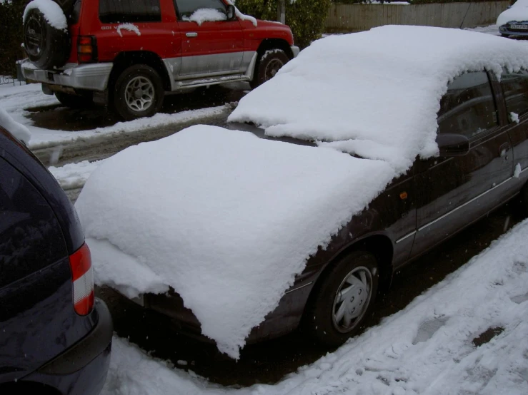 the cars are covered in snow while parked