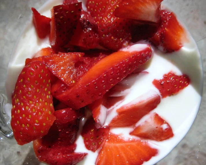 strawberries and milk in a bowl with some spoons