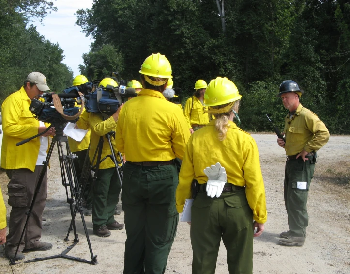 firemen are standing around while looking at soing