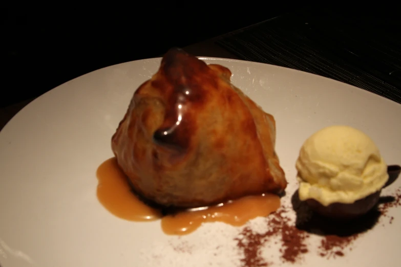 a plate with a dessert next to a scoop of ice cream