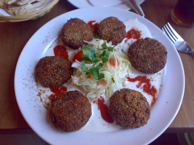 a white plate topped with meatballs covered in sauce